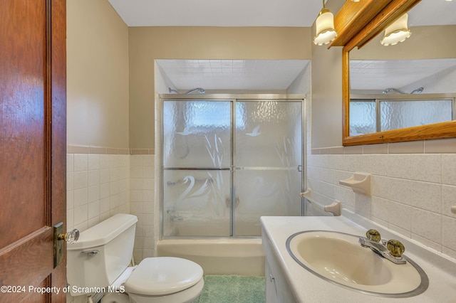 bathroom featuring vanity, toilet, tile walls, and a shower with shower door