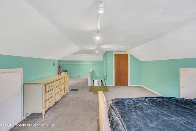 bedroom featuring light carpet and vaulted ceiling