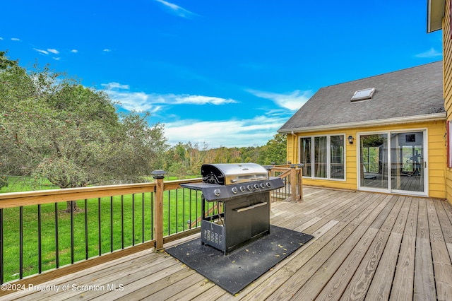 wooden deck with a lawn and area for grilling