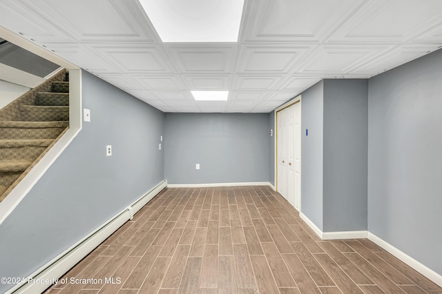 basement featuring hardwood / wood-style floors and baseboard heating