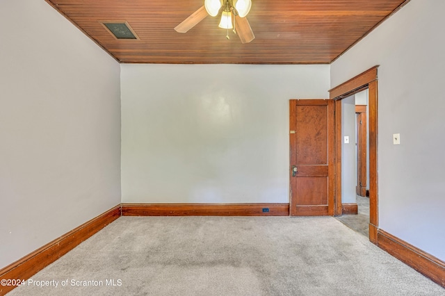 spare room with ceiling fan, carpet, and wooden ceiling