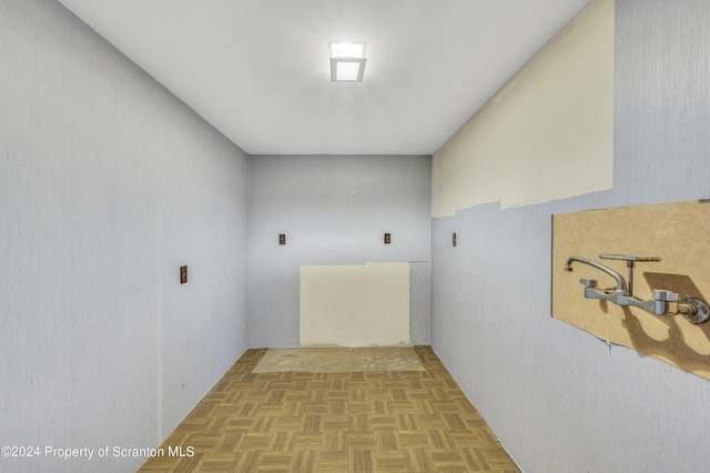 clothes washing area with light parquet flooring