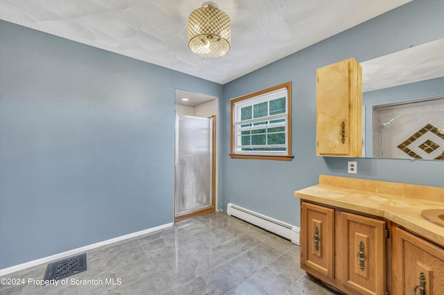 bathroom with vanity, an enclosed shower, and a baseboard heating unit