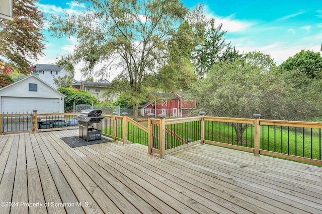 wooden terrace with grilling area, an outdoor structure, and a garage