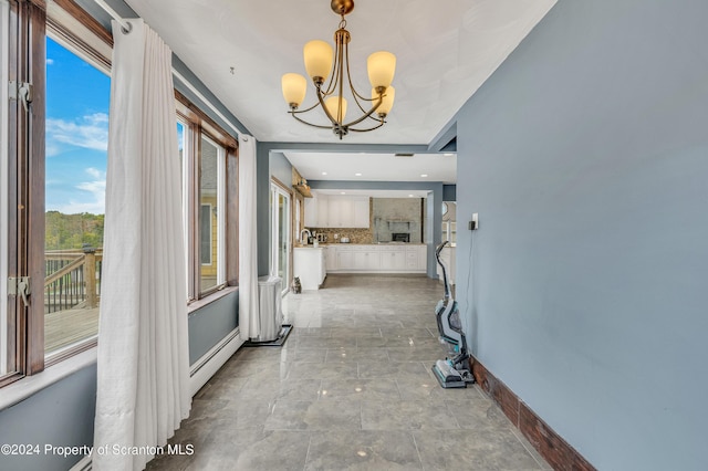 hallway featuring sink and a chandelier