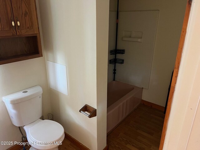 bathroom with wood finished floors, toilet, and baseboards