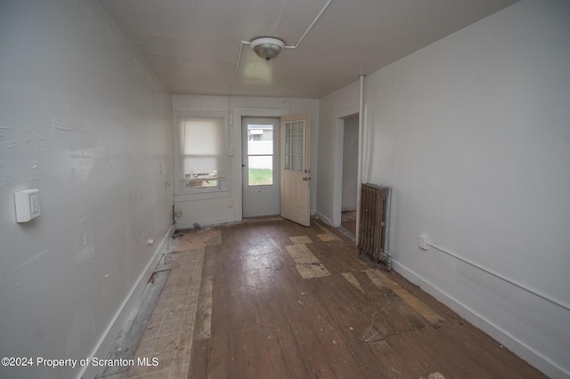 entryway with dark hardwood / wood-style flooring and radiator heating unit