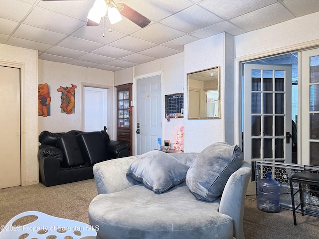 living room with carpet, ceiling fan, and a paneled ceiling