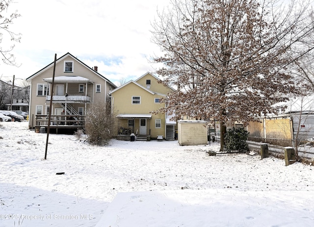 view of snow covered back of property