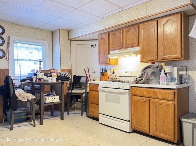 kitchen featuring light tile patterned floors, white range, and a drop ceiling