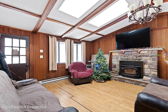 living room with hardwood / wood-style floors, a notable chandelier, wooden walls, and a baseboard radiator