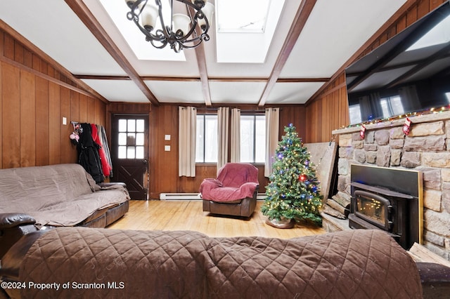 living room with a baseboard radiator, an inviting chandelier, light hardwood / wood-style flooring, vaulted ceiling with beams, and wood walls