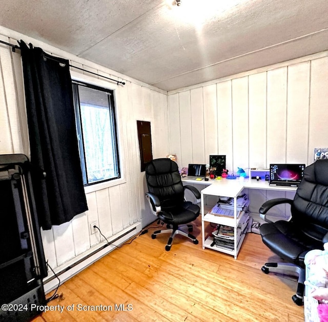 office featuring a textured ceiling, light hardwood / wood-style floors, and a baseboard radiator