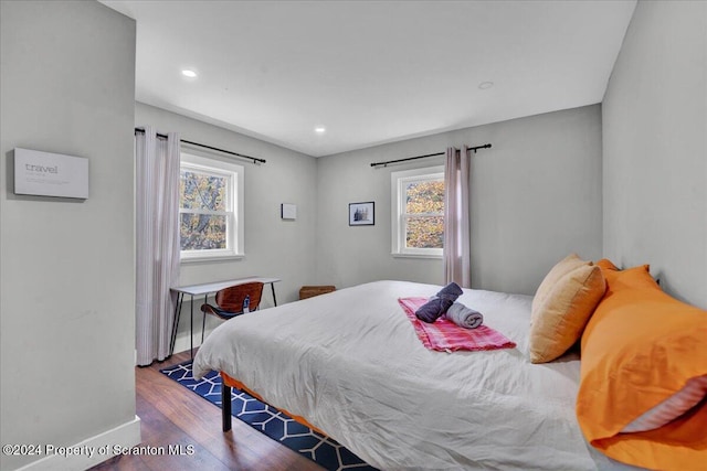 bedroom with dark hardwood / wood-style flooring