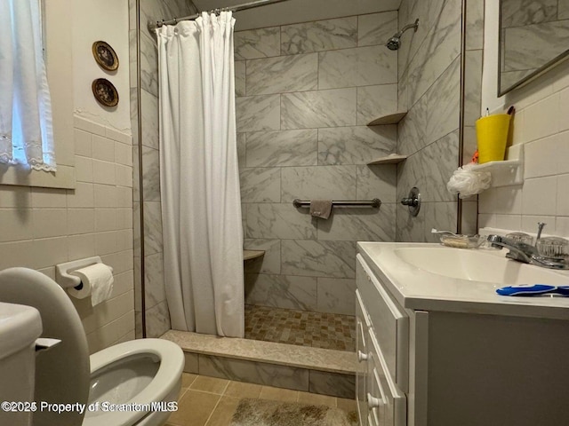 bathroom featuring tiled shower, toilet, tile walls, and vanity