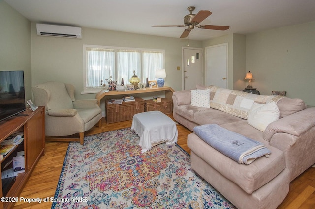 living area featuring light wood-style flooring, an AC wall unit, and ceiling fan