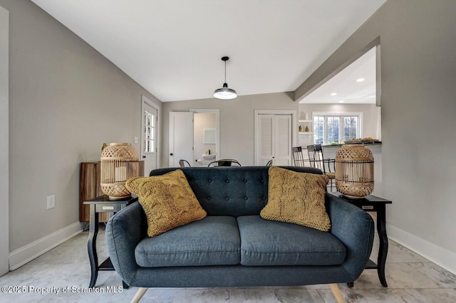 living room with vaulted ceiling and baseboards