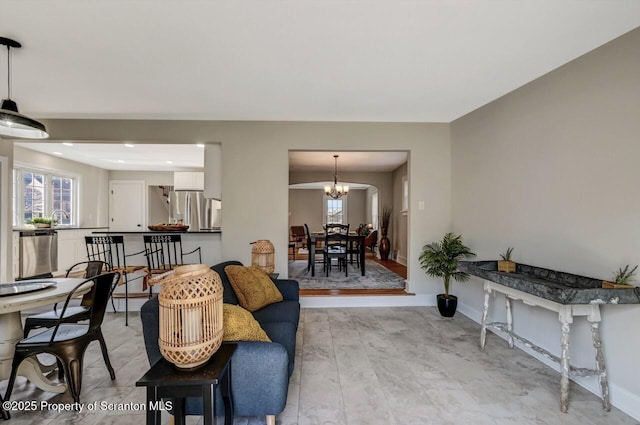 living room with baseboards and an inviting chandelier