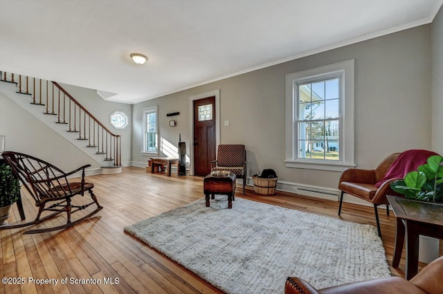 entrance foyer featuring baseboards, ornamental molding, stairs, light wood-style floors, and a baseboard heating unit