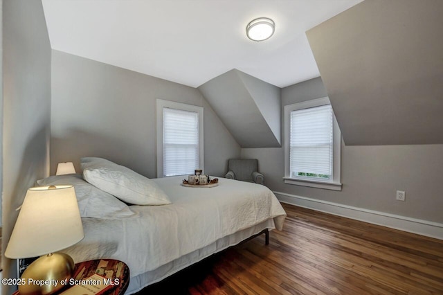 bedroom featuring baseboards, vaulted ceiling, and wood finished floors