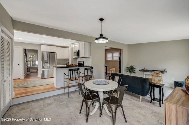 dining room featuring recessed lighting, plenty of natural light, and baseboards