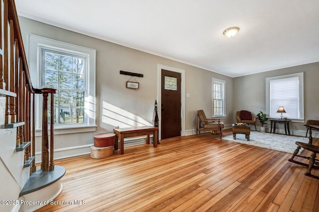 foyer entrance featuring hardwood / wood-style flooring, stairs, and baseboards