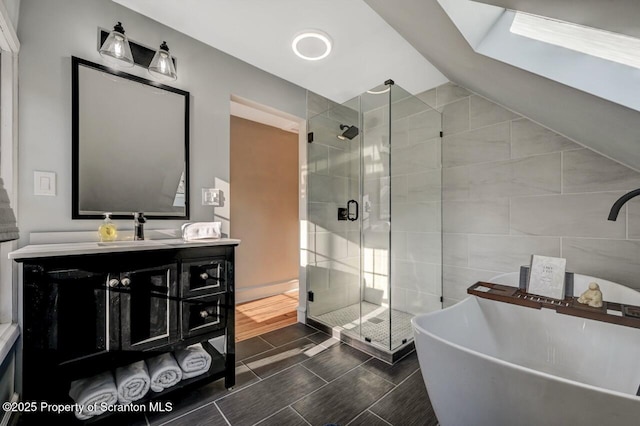 full bathroom featuring a freestanding tub, wood finish floors, vanity, vaulted ceiling, and a shower stall