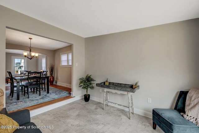 interior space featuring baseboards and a notable chandelier