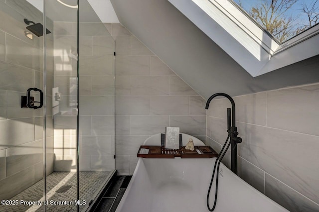 full bath with a stall shower, tile walls, and a freestanding bath