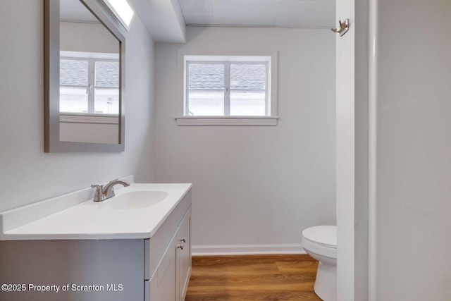 bathroom featuring vanity, toilet, hardwood / wood-style floors, and plenty of natural light