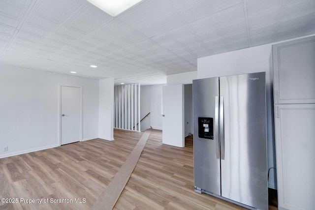 interior space featuring light hardwood / wood-style floors and stainless steel refrigerator with ice dispenser