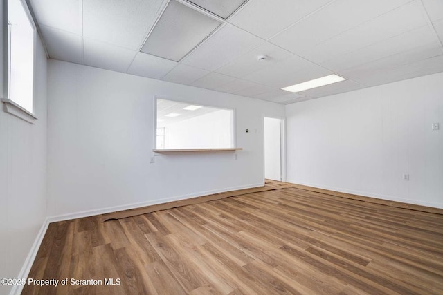 unfurnished room with wood-type flooring and a paneled ceiling