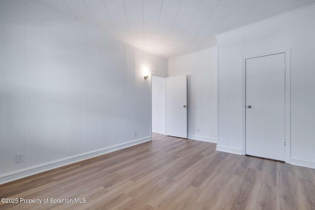 unfurnished room featuring crown molding and light hardwood / wood-style floors