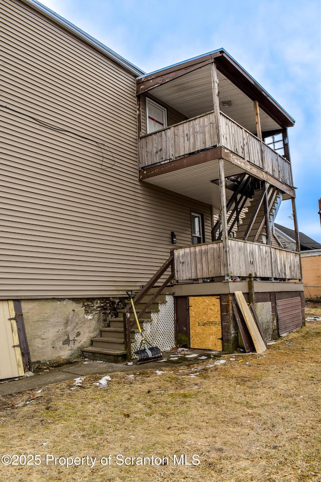 rear view of house with stairs and a wooden deck