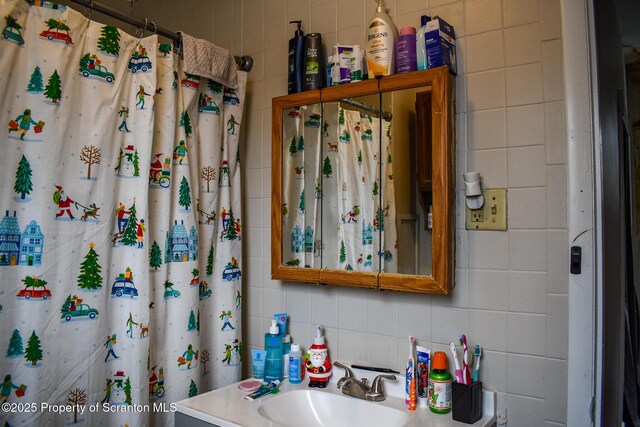 bathroom featuring tile walls, decorative backsplash, and vanity