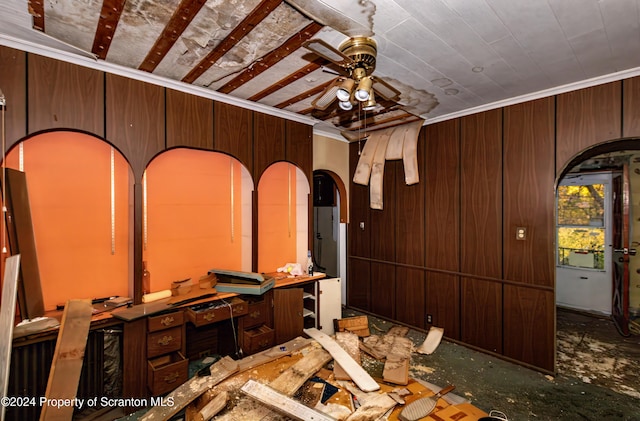 miscellaneous room featuring ceiling fan, ornamental molding, and wood walls