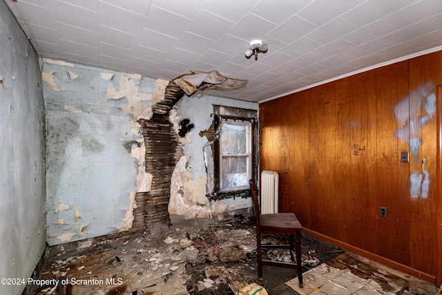 miscellaneous room featuring wooden walls, ornamental molding, and radiator