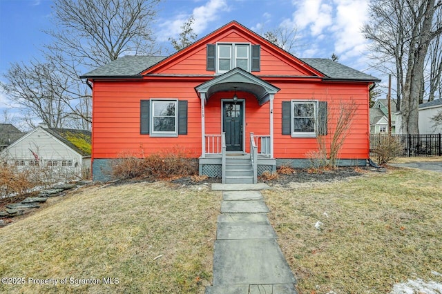 bungalow with a shingled roof and a front lawn