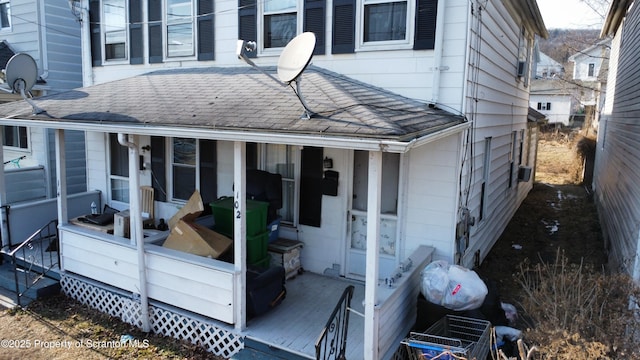 view of side of home with roof with shingles