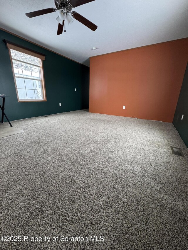 carpeted empty room featuring ceiling fan