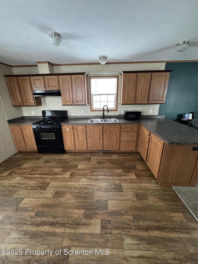 kitchen with crown molding, sink, black appliances, and dark hardwood / wood-style floors