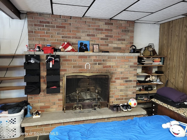 bedroom featuring a fireplace and concrete block wall