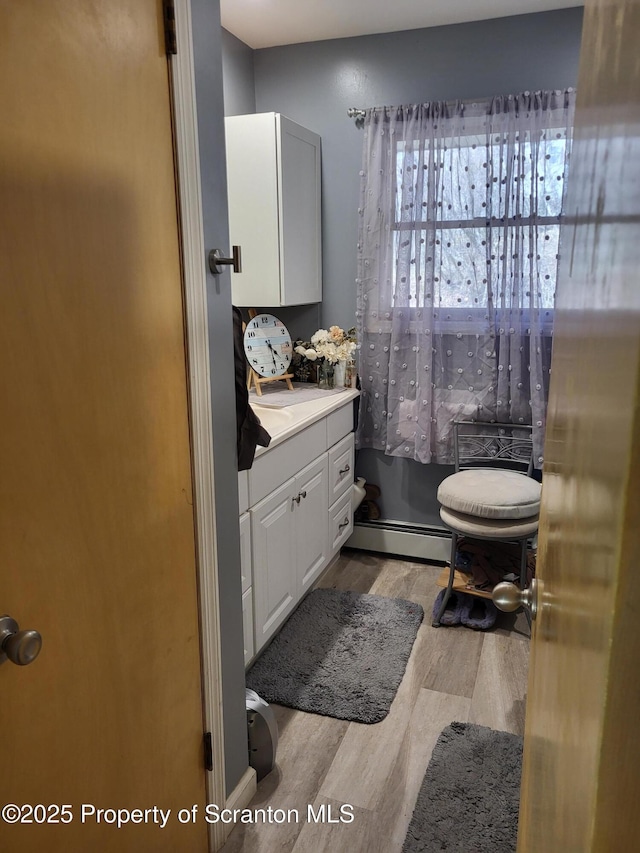 bathroom featuring a baseboard radiator, vanity, and wood finished floors