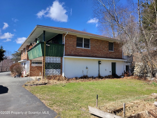 view of property exterior with a yard and brick siding