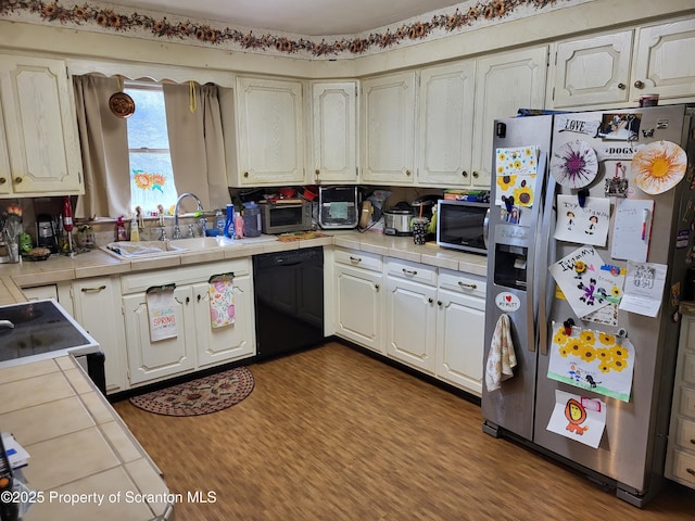 kitchen featuring a sink, dark wood-style flooring, appliances with stainless steel finishes, tile counters, and white cabinetry