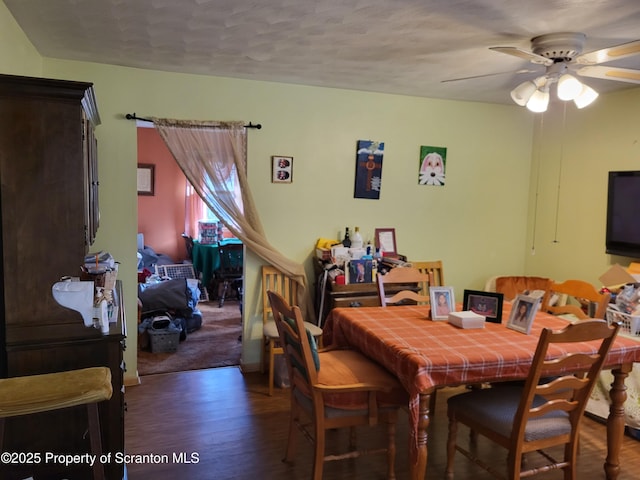 dining space with a ceiling fan and wood finished floors