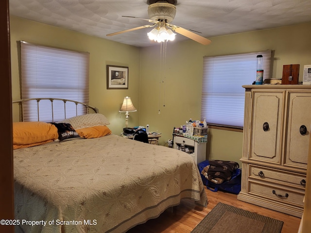 bedroom with light wood-style floors and a ceiling fan