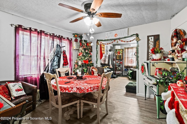 dining area featuring ceiling fan, wood-type flooring, and a textured ceiling