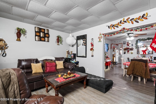 living room with hardwood / wood-style floors, ceiling fan, and a drop ceiling