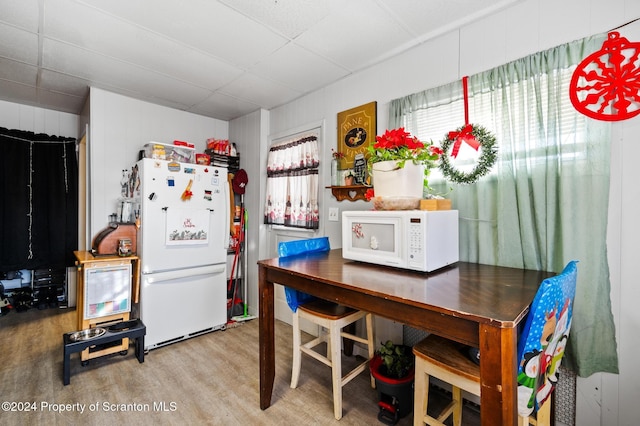 kitchen featuring a drop ceiling, wood-type flooring, and white appliances